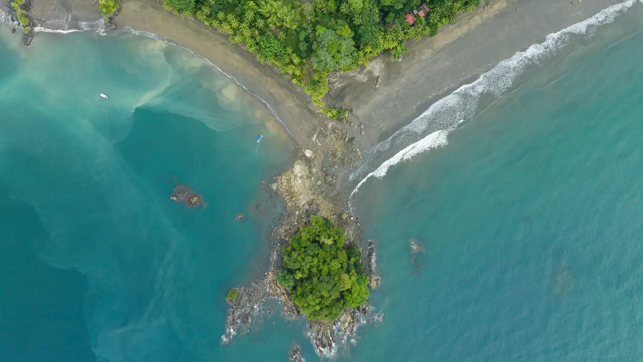 Vista aérea desde un dron de una península en la costa pacífica colombiana, con playa y mar turquesa a ambos lados